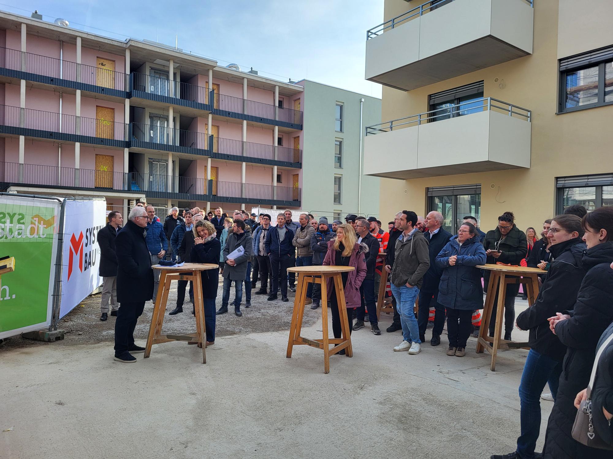 Menschen schauen sich Feier der Dachgleiche an